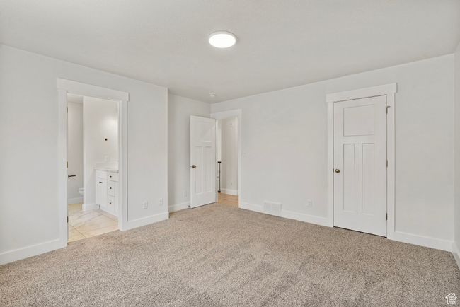 Unfurnished bedroom featuring light carpet and ensuite bathroom | Image 11