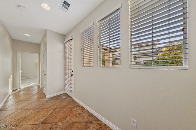 Corridor featuring healthy amount of natural light, stone finish flooring, and recessed lighting | Image 13