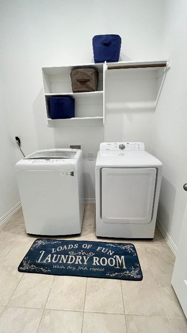 Laundry area featuring washing machine and clothes dryer, baseboards, and tile patterned floors | Image 17