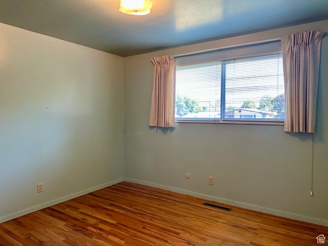 Bedroom featuring wood finished floors, plenty of light and baseboards | Image 13