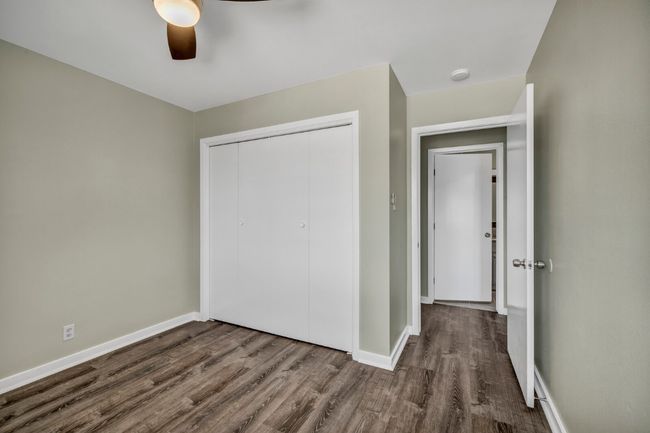 Unfurnished bedroom with wood finished floors, a closet, baseboards, and a ceiling fan | Image 20