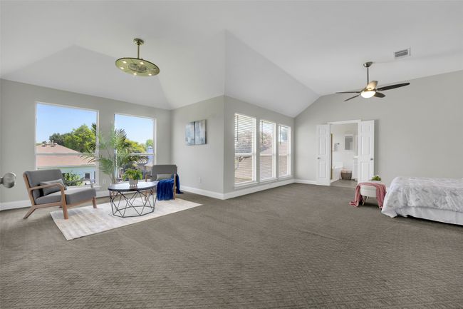 Bedroom with vaulted ceiling, carpet flooring, and connected bathroom | Image 24