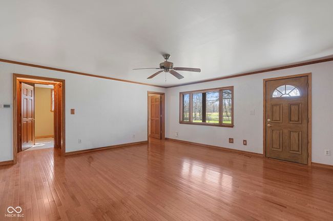 foyer with ceiling fan, light wood-style flooring, baseboards, and ornamental molding | Image 16