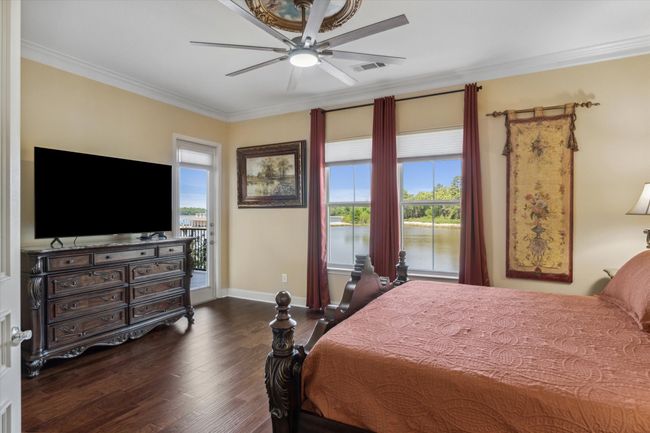 Bedroom with crown molding, dark wood-style flooring, multiple windows, baseboards, and a ceiling fan | Image 11