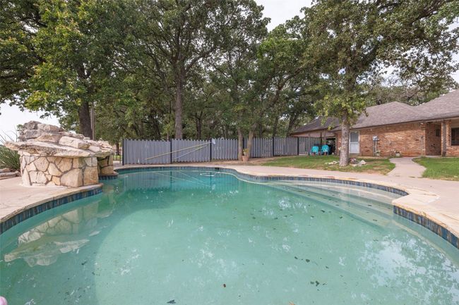 View of swimming pool with fence and a fenced in pool | Image 24