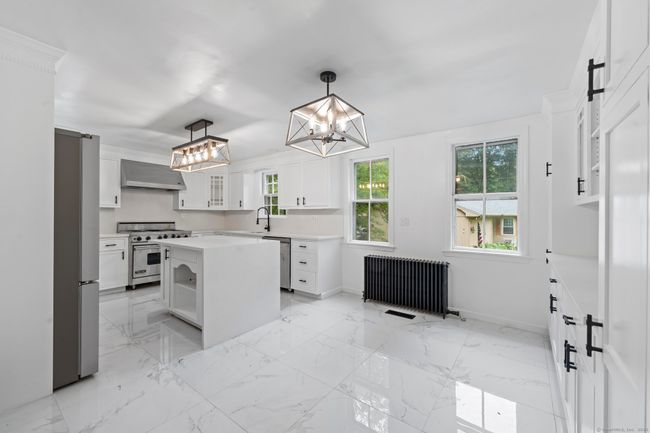 The kitchen has beautiful quartz counters and back-splash. | Image 8