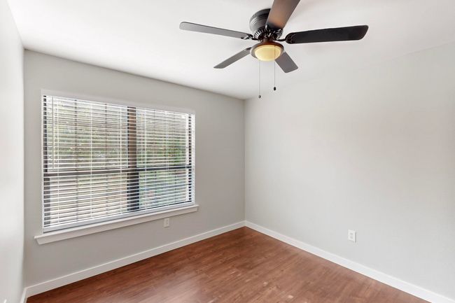 Spare room featuring a ceiling fan, wood finished floors, and baseboards | Image 25
