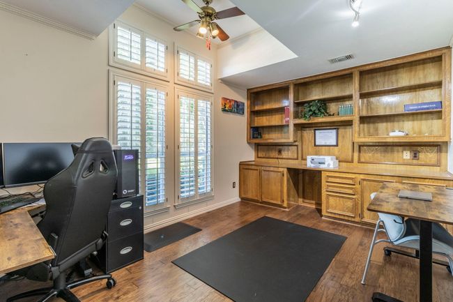 Home office with ceiling fan, plenty of natural light, ornamental molding, and dark wood-style flooring | Image 27