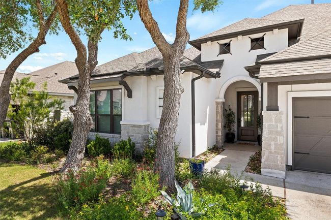 View of front of home with stucco siding, stone siding, and roof with shingles | Image 4