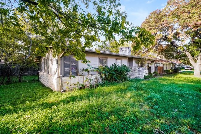View of side of home with a chimney, a yard, and stone siding | Image 4