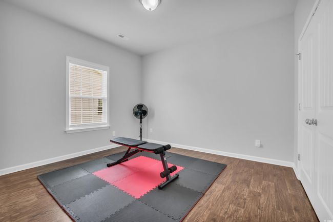 Exercise room featuring wood finished floors, visible vents, and baseboards/second guest bedroom. | Image 13