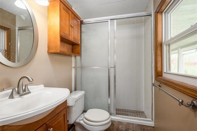 Bathroom with toilet, vanity, and a stall shower | Image 23
