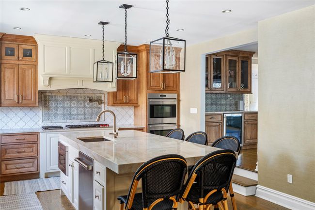 Kitchen featuring a sink, beverage cooler, brown cabinets, and dark wood-style flooring | Image 18