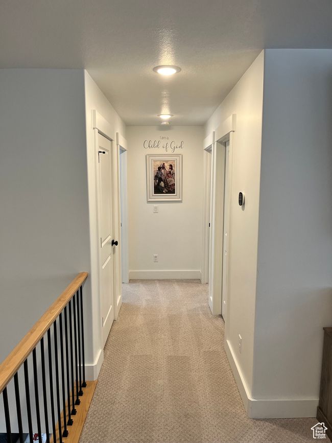 Hall featuring baseboards, a textured ceiling, and light carpet | Image 11