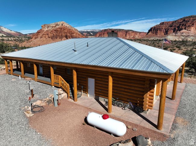 View of side of home with log siding, a chimney, metal roof, and a mountain view | Image 6