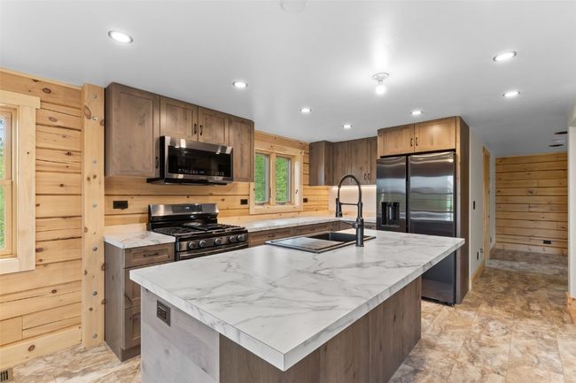 Kitchen featuring farmer's sink in the center island with stainless appliances | Image 14