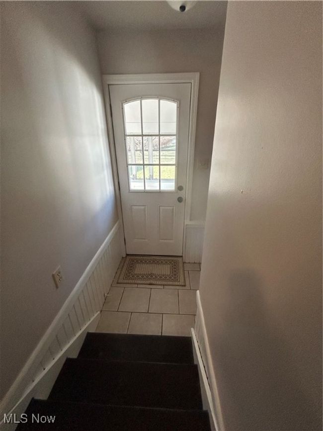 Entryway featuring light tile patterned floors and stairs leads out to sunroom. | Image 26