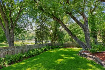 The fully fenced backyard oasis extends beyond the fence to the pond offering an additional large area for gardens, entertaining and play. | Image 2