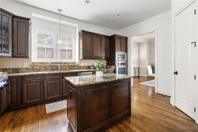 10' Ceilings, Surround sound, Island with storage, Kitchen Aid 5 burner gas range, Kitchen aid wall oven, Whirpool wall microwave, Kitchen aid stainless steel refrigerator and dishwasher, Granite countertops, Recessed and pendant lighting, Double bowl stainless sink, corner pantry, decorative tile behind the range, tile backsplash, bar seating. | Image 12
