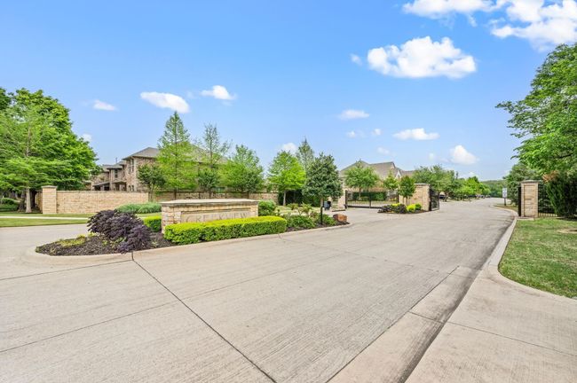 View of concrete road with a gated entry and curbs | Image 31