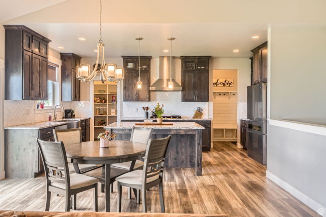 Dining room with light wood finished floors, a chandelier, and recessed lighting | Image 10