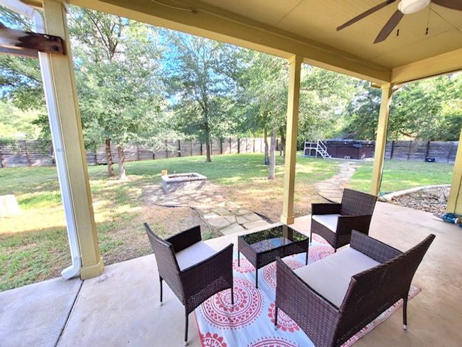 View of patio / terrace featuring a ceiling fan, an outdoor living space with a fire pit, and a fenced backyard | Image 20