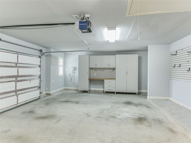 Garage door is insulated and the 1/2 car bump out offers more space for storage with these cabinets and natural light through the window. | Image 32