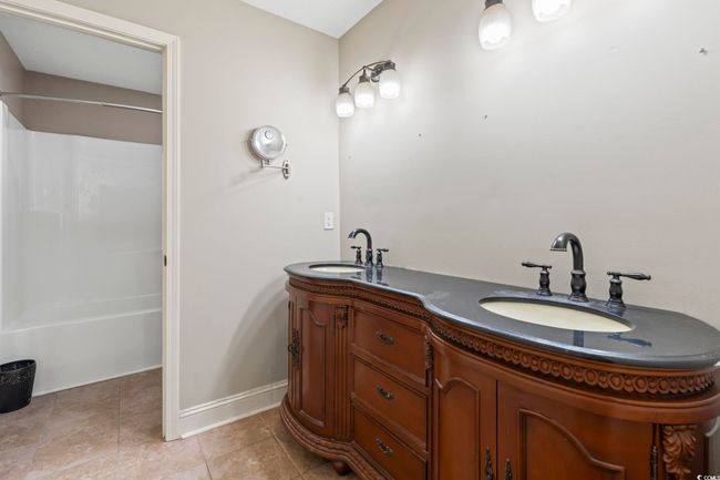 Bathroom with double vanity, shower / tub combination, and tile patterned floors | Image 23