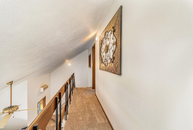 The upper level hall overlooks the stunning great room. | Image 28