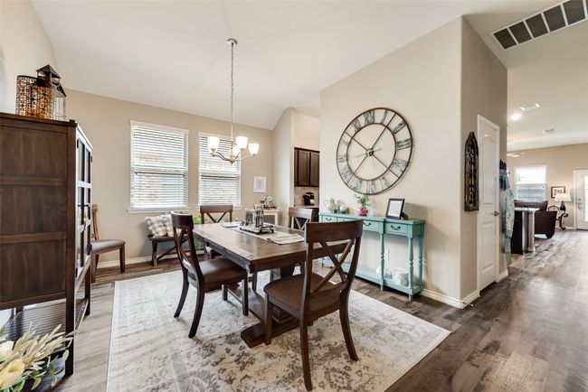 Dining room with a chandelier, light wood-style flooring, and vaulted ceiling | Image 6