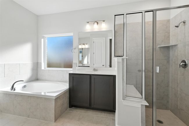 Bathroom featuring a stall shower, a garden tub, vanity, and tile patterned floors | Image 15