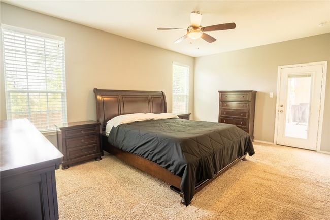 Bedroom featuring light carpet, multiple windows, and ceiling fan | Image 13