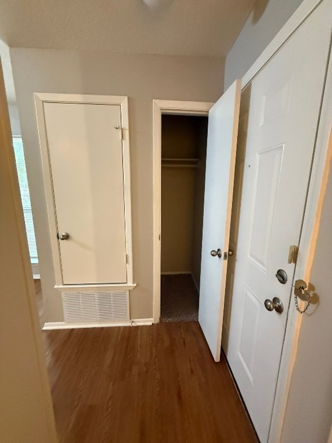 Unfurnished bedroom with dark wood-type flooring and a walk in closet | Image 11