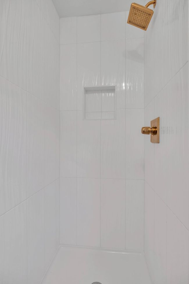 Full bathroom downstairs shower with tiled and new fixtures. | Image 29