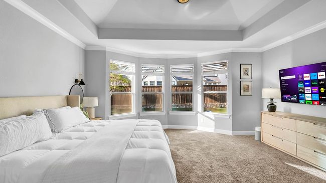 Bedroom featuring a raised ceiling, crown molding, carpet flooring, and baseboards | Image 11