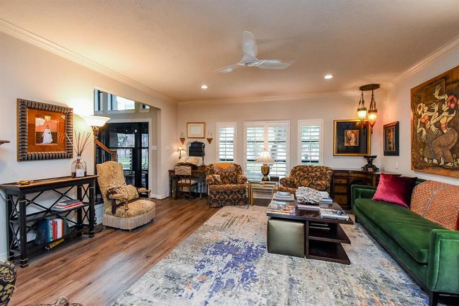 View of the living room from the dining room. Notice the bank of windows dressed with custom plantation shutters. | Image 10