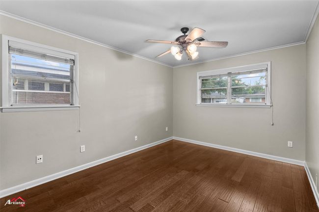 Spare room featuring wood finished floors, ceiling fan, ornamental molding, and baseboards | Image 13
