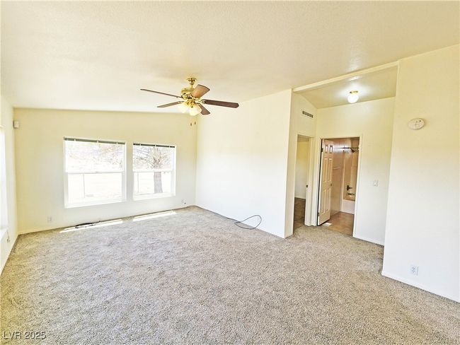 Carpeted empty room with ceiling fan and visible vents | Image 14
