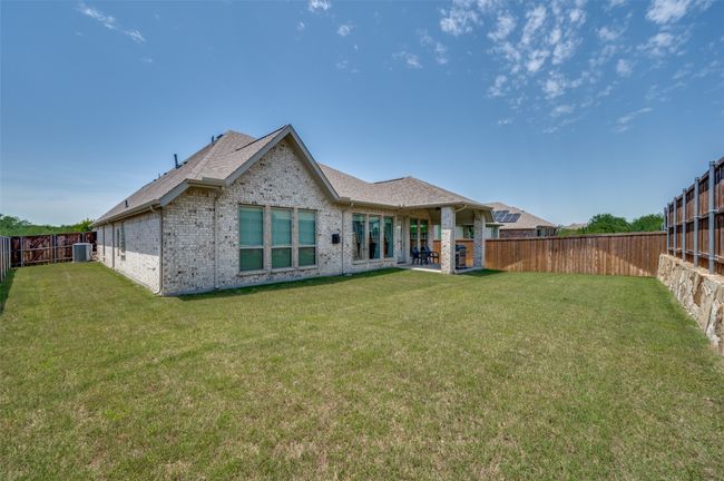Rear view of property featuring brick siding, cooling unit, a patio, and roof with shingles | Image 25