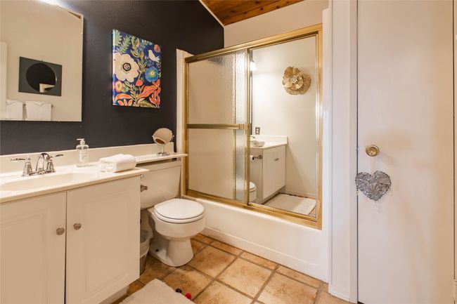 Bathroom featuring toilet, enclosed tub / shower combo, and vanity | Image 7