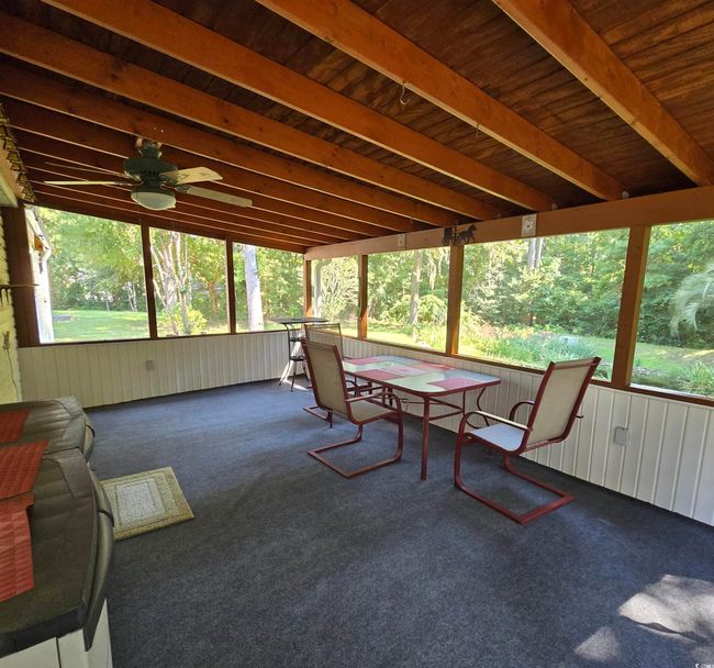 Sunroom / solarium with healthy amount of natural light, outdoor dining area, and a ceiling fan | Image 32