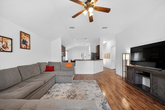 Living room featuring lofted ceiling, a ceiling fan, dark wood-style flooring, and recessed lighting | Image 33