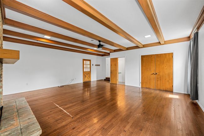 Unfurnished living room with beamed ceiling and wood finished floors | Image 10