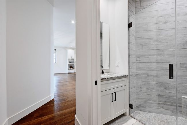 Bathroom with vanity, a shower stall, wood finished floors, and baseboards | Image 26