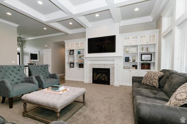 Living room featuring light colored carpet, crown molding, beam ceiling, and recessed lighting | Image 29