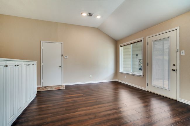Empty room with lofted ceiling, dark wood-type flooring, and recessed lighting | Image 9