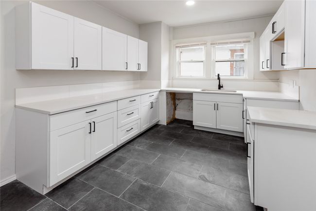 Kitchen with a sink, white cabinetry, and light countertops | Image 36