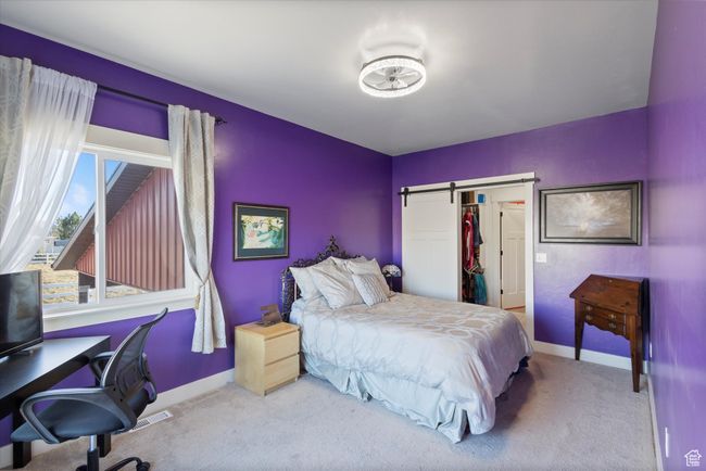Bedroom with a closet, baseboards, a barn door, and carpet floors | Image 20