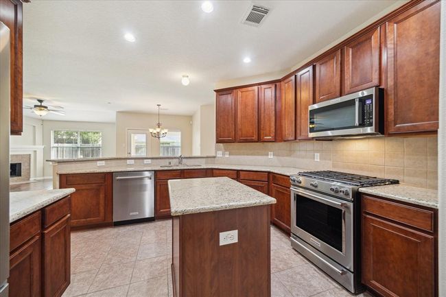 The kitchen offers ample cabinetry and a generous countertop space, making meal preparation a joy. | Image 11