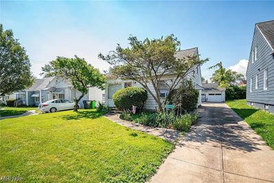 View of front of property featuring a front lawn, a garage, and an outdoor structure | Image 3